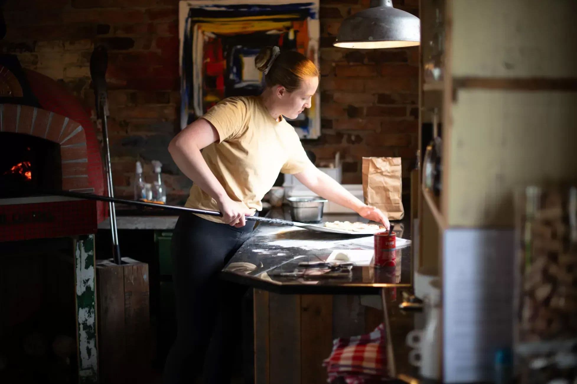 Jente som står og lager italiensk pizza